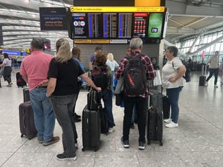 Passengers at Heathrow check for updates on their flight delays (Maja Smiejkowska/PA)